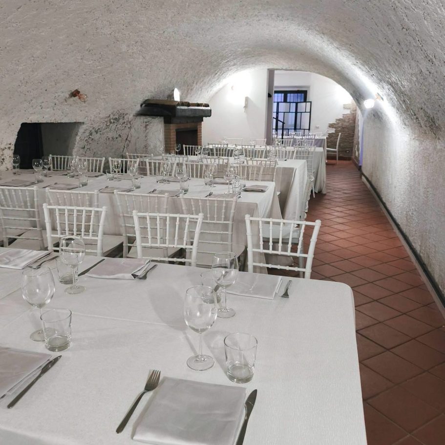 Modern restaurant interior with wooden tables and white chairs, softly lit with blue lights.